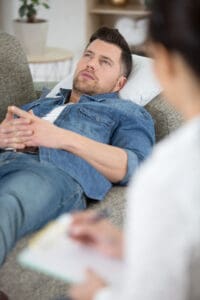 businessman on sofa talking to his therapist at therapy session