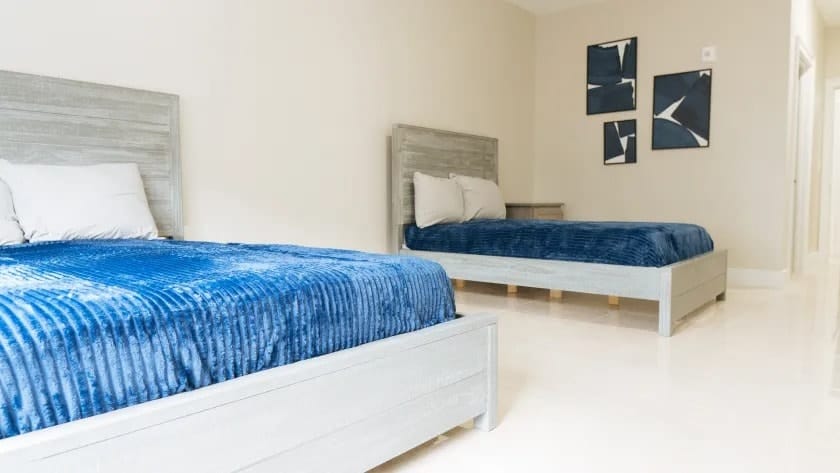 2 beds in a room with blue covers