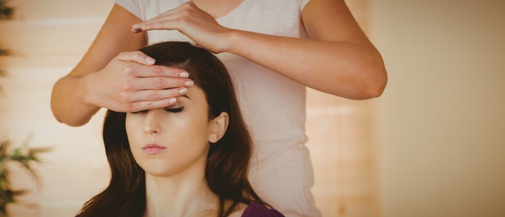 A woman getting Reiki treatment during a complimentary therapy session in Atlanta